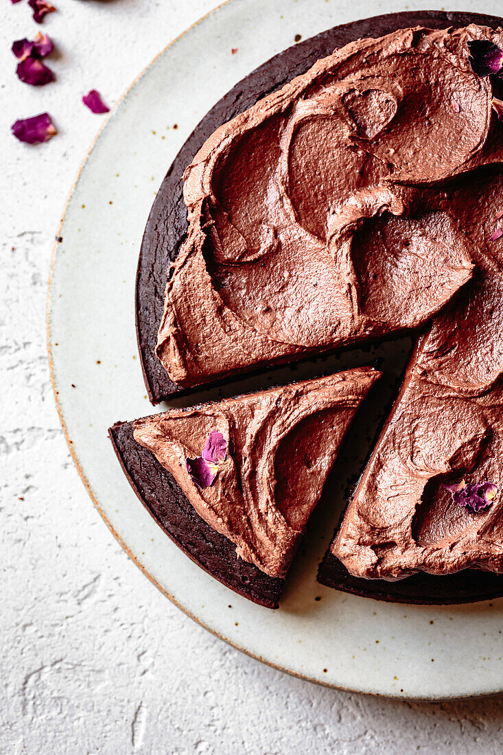 Chocolate cake with chocolate icing and dried rose petals