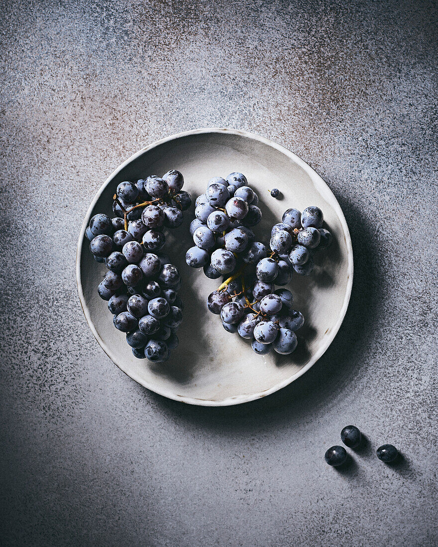 Thomcord Grapes on a Grey Plate