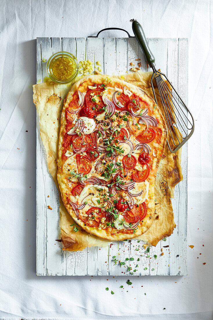 Hausgemachte Käse-Tomaten-Pizza auf einem Holzschneidebrett