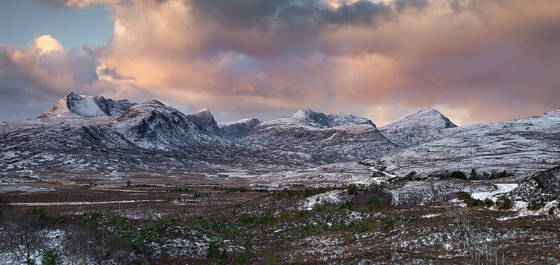 Sonnenaufgang über den Bergen von Assynt im Winter, Ben Mor Coigach, Beinn Tarsuinn, Sgurr an Fhidhleir, Beinn an Eoin und Sgorr Tuath mit Lochan Tuath darunter, Assynt, Assynt-Coigach National Scenic Area, Sutherland, Schottische Highlands, Schottland, Vereinigtes Königreich, Europa