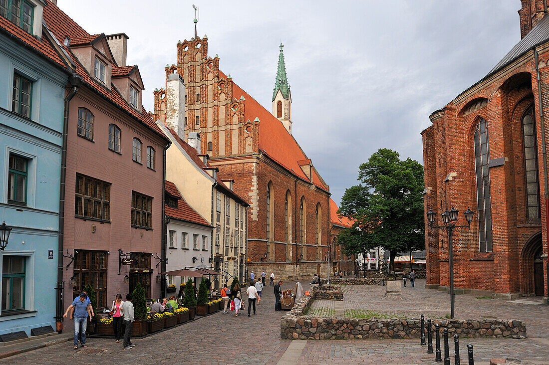 Terrace of the restaurant Domini Canes facing St. Peter' Church in Skarnu Street with St. John's Church in the background, Old Town, Riga, Latvia, Baltic region, Europe