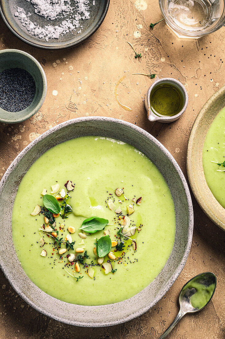 Green soup bowl with herbs on a brown background