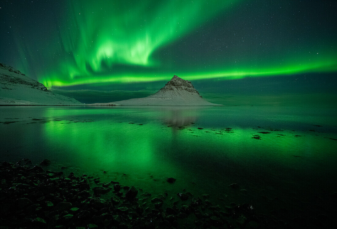 Aurora borealis (Northern Lights) over Kirkjufell Mountain (Wizard's Hat) reflected in ocean, Iceland, Polar Regions