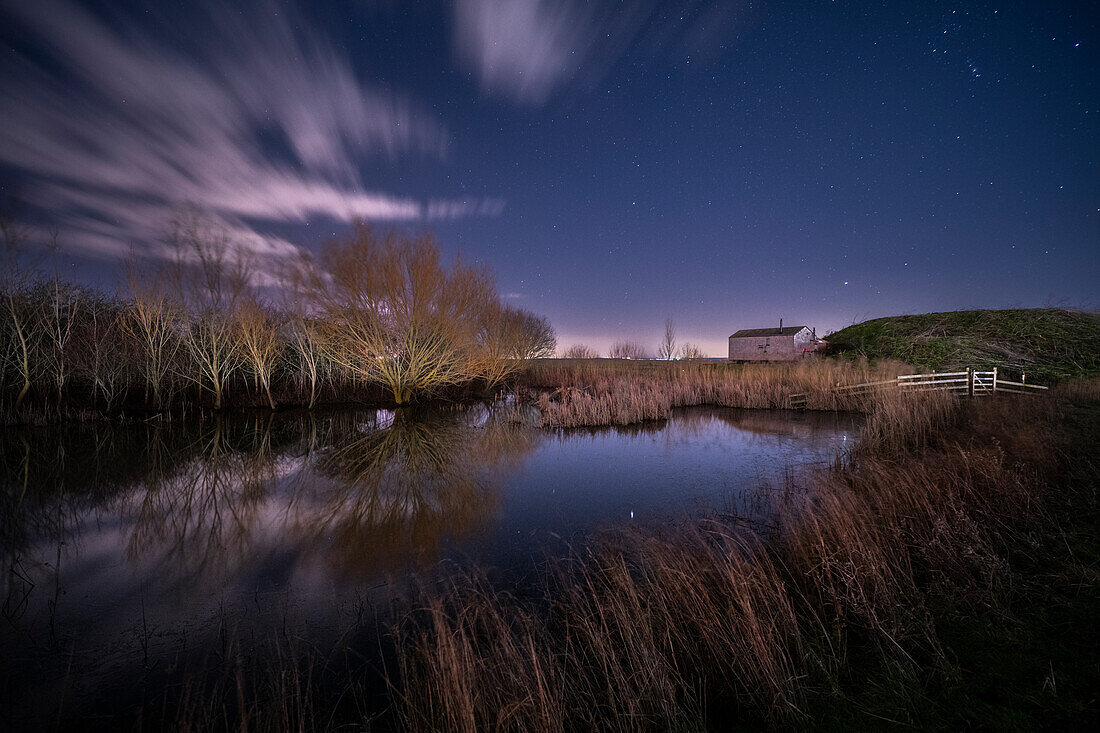 Shepherd Hut und Teich bei Nacht, beleuchtet vom Mondlicht, Elmley Nature Reserve, Kent, England, Vereinigtes Königreich, Europa