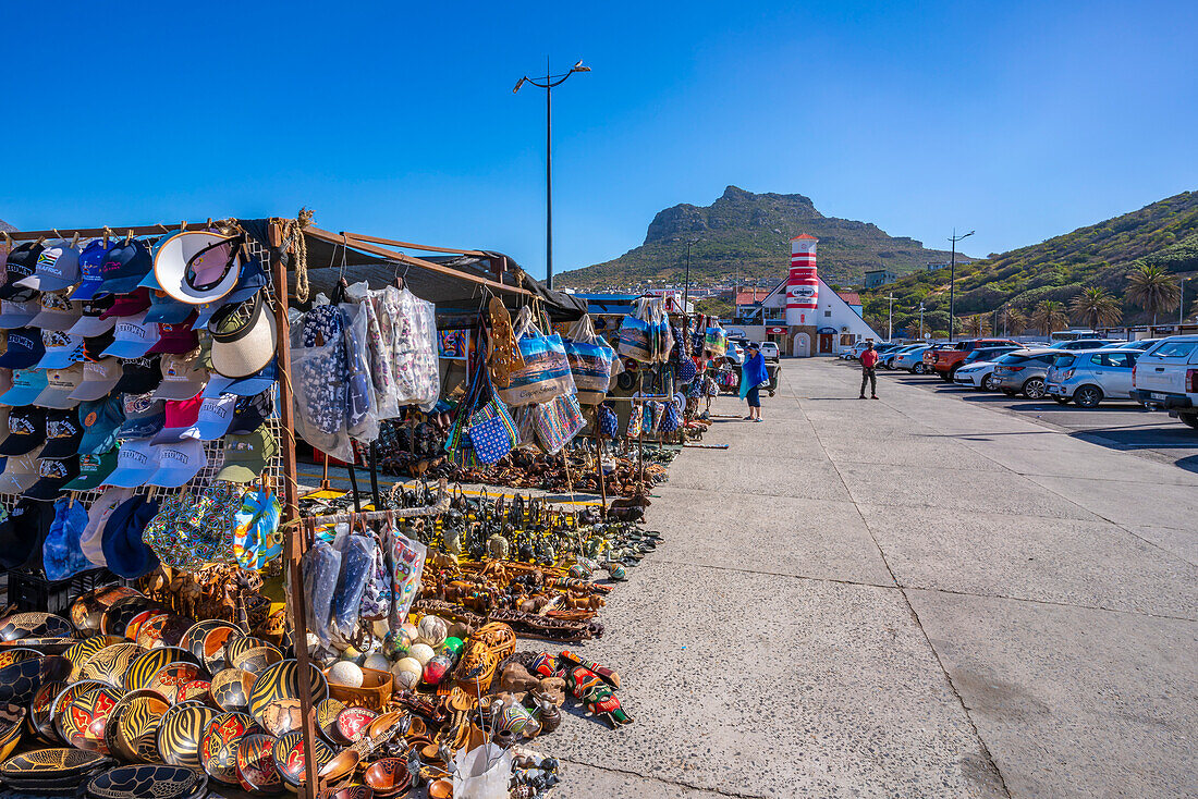 Blick auf Souvenirstände und bunte Bar und Leuchtturm in Hout Bay Harbour, Hout Bay, Kapstadt, Westkap, Südafrika, Afrika