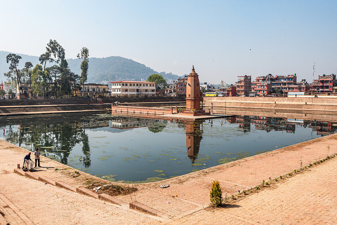 Bhajya Pukhu-Wasserbecken mit einem alten Turm inmitten von Bhaktapur in der Nähe von Kathmandu, Nepal, Asien