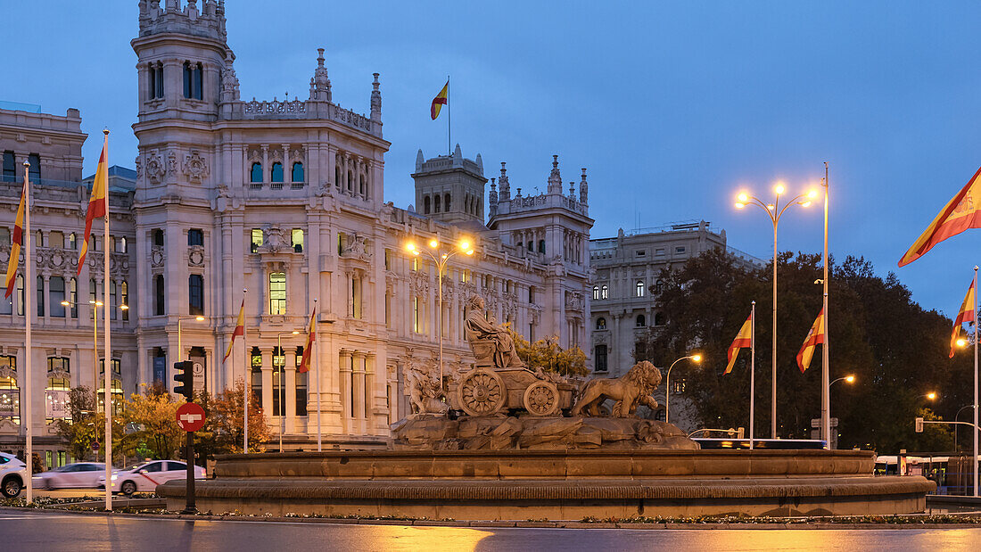 Blick auf die Plaza de Cibeles mit dem majestätischen Cibeles-Palast im Hintergrund und dem berühmten Cibeles-Brunnen im Vordergrund, Madrid, Spanien, Europa