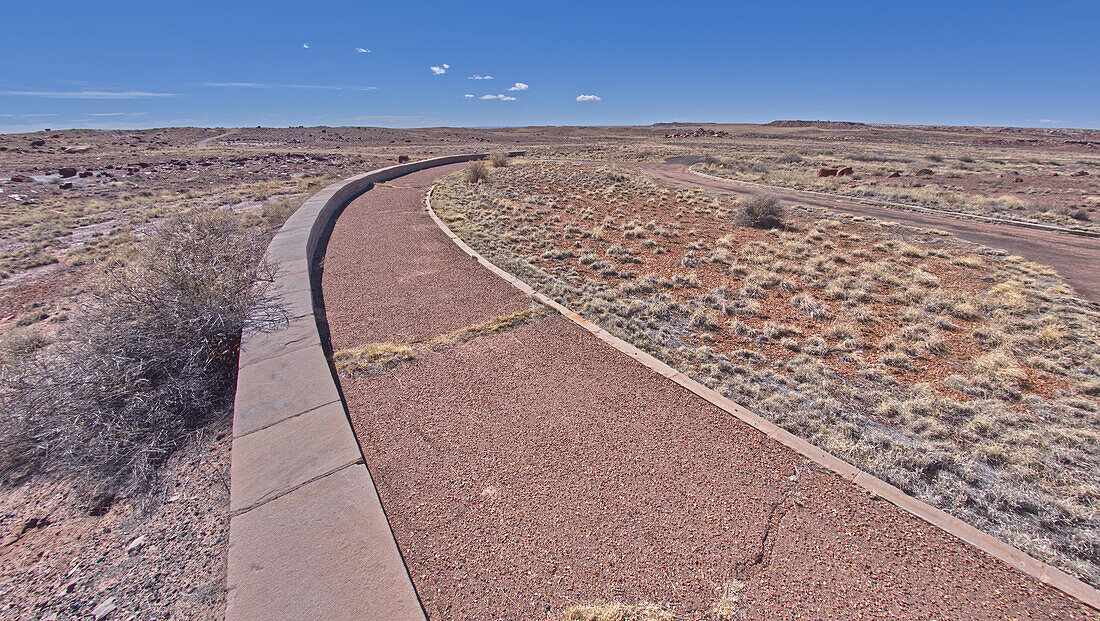 Ein gepflasterter Weg führt zum Eingang des Long Logs Trail im Petrified Forest National Park, Arizona, Vereinigte Staaten von Amerika, Nordamerika