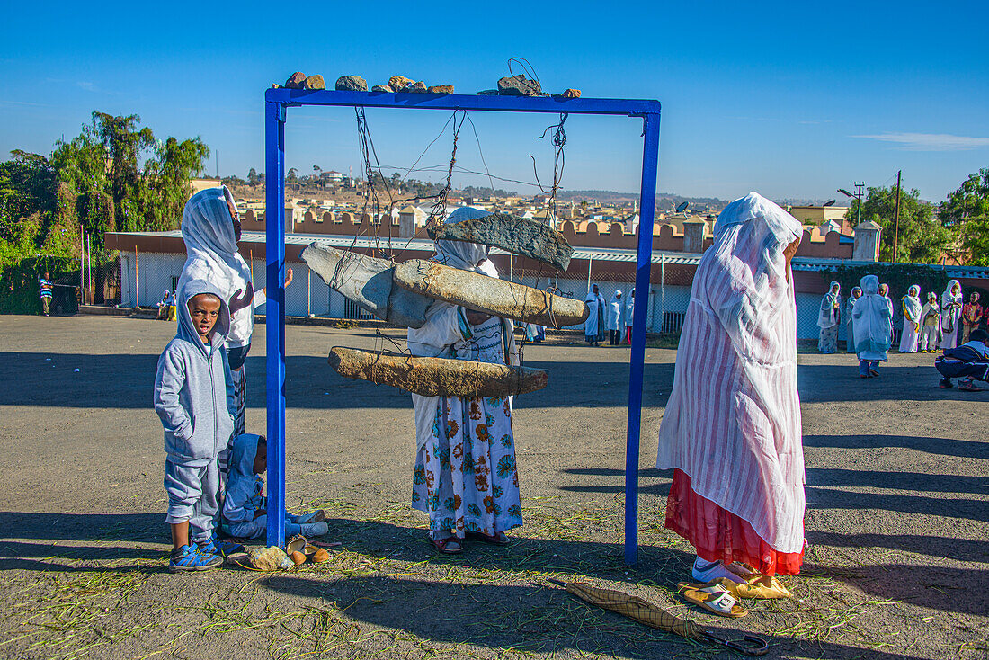 Pilgrims at an old stone bell at the Coptic Cathedral of St. Mariam, Asmara, Eritrea, Africa