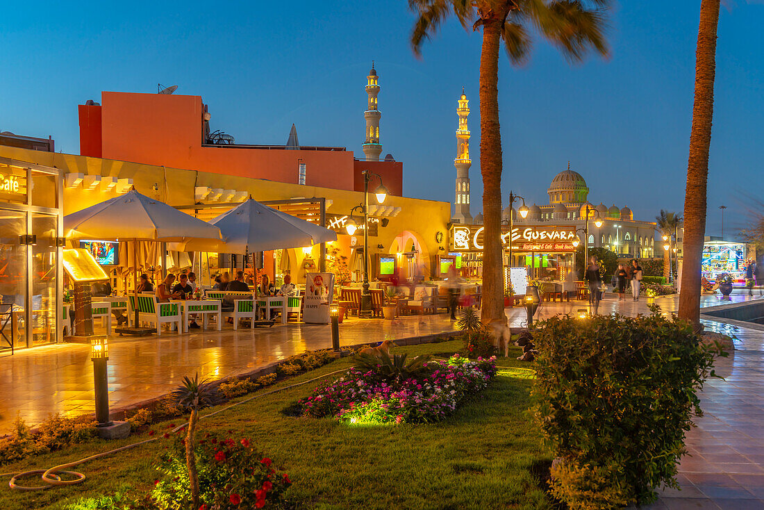 View of cafe and restaurant in Hurghada Marina and Al Mina Mosque in background at dusk, Hurghada, Red Sea Governorate, Egypt, North Africa, Africa