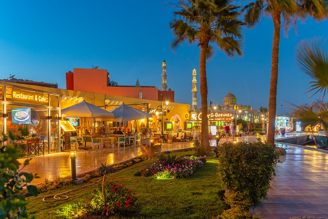 Blick auf Café und Restaurant im Yachthafen von Hurghada und die Al-Mina-Moschee im Hintergrund in der Abenddämmerung, Hurghada, Verwaltungsbezirk Rotes Meer, Ägypten, Nordafrika, Afrika