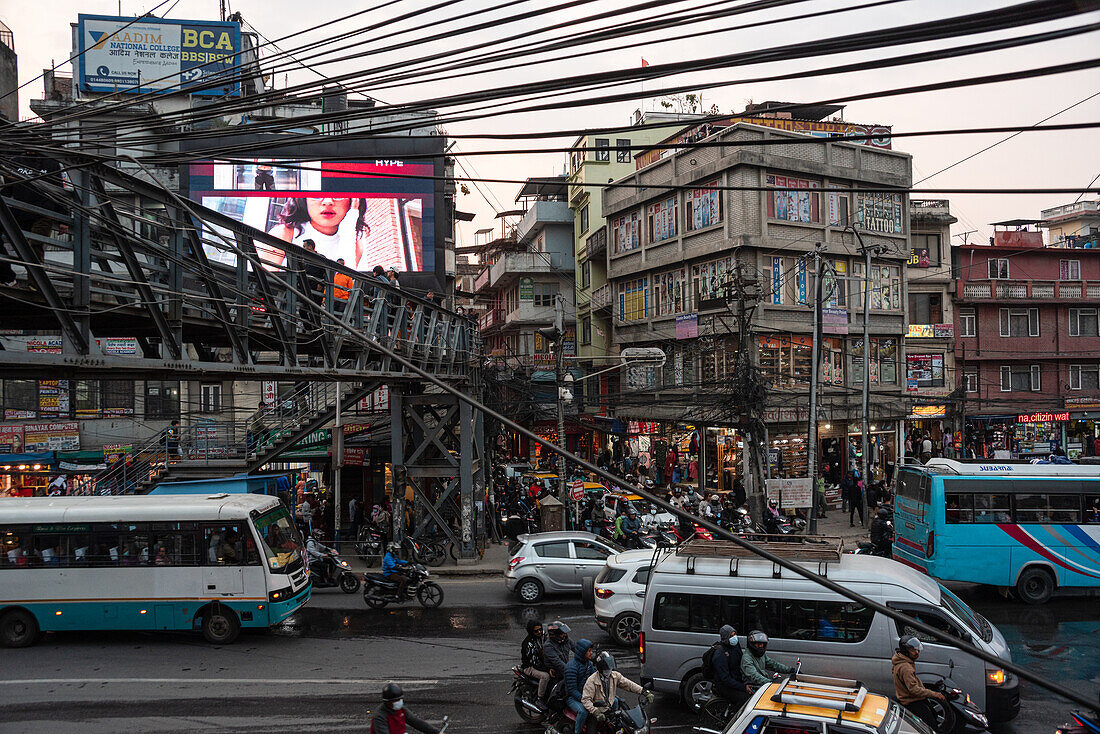 Elektrische Drähte über der chaotischen Szene der Ringstraßen-Kreuzung mit massivem Verkehr, Chabahil, Kathmandu, Nepal, Asien