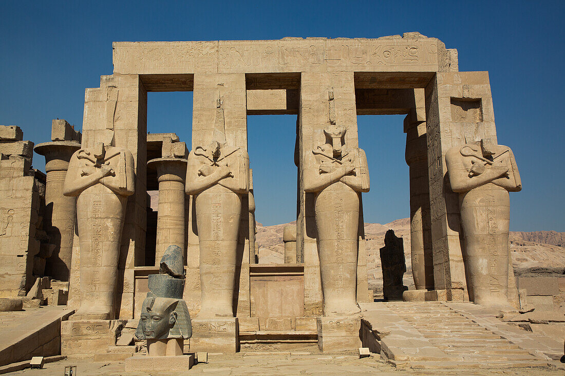 Granitkopf von Ramses II. vor den Osiris-Statuen, Ramesseum, Gedächtnistempel des Pharao Ramses II., 13. Jahrhundert v. Chr., Antikes Theben, UNESCO-Welterbe, Luxor, Ägypten, Nordafrika, Afrika