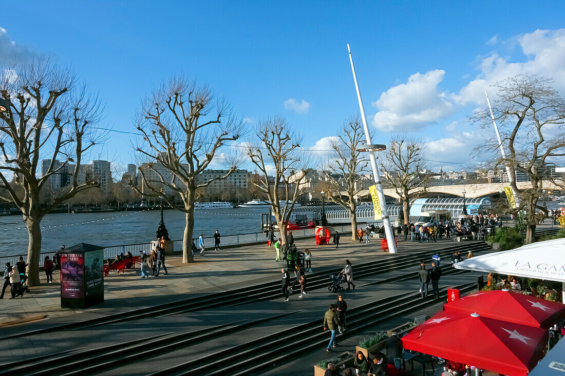 Menschen schlendern und picknicken am Südufer der Themse in der Nähe der Royal Festival Hall, London, England, Vereinigtes Königreich, Europa