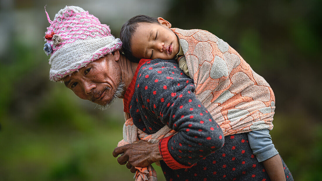 Nyishi Tribe, man carrying sleeping child on his back, Ziro Valley, Arunachal Pradesh, India, Asia