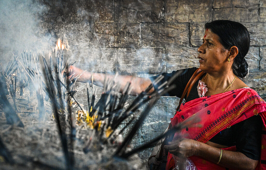 Woman devotee and incense sticks, Kamakhya Temple, Guwahati, Assam, India, Asia