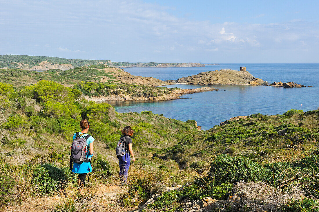 Hikers on the Cami de Cavalls, hiking trail GR 223, with the headland and watchtower Es Colomar in the background, s'Albufera des Grau Natural Park, Menorca, Balearic Islands, Spain, Mediterranean, Europe