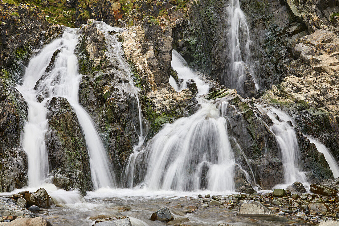 Waterfall pouring down a rocky cliff, with blurred motion, resulting from a slow shutter speed; at Welcombe Mouth, Hartland, north Devon, England, United Kingdom, Europe