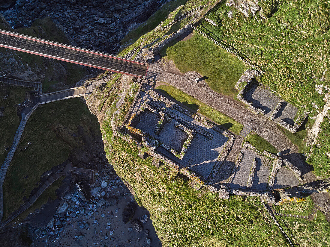 Eine Luftaufnahme der dramatischen Ruinen von Tintagel Castle, angeblich der Geburtsort von König Artus, auf einer felsigen Insel vor der Küste, nahe der Stadt Tintagel, Cornwall, England, Vereinigtes Königreich, Europa