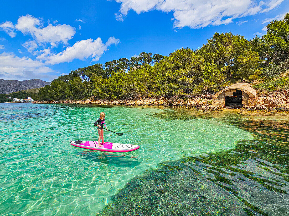 Mädchen auf einem SUP in den türkisfarbenen Gewässern der Halbinsel Formentor, Mallorca, Balearen, Spanien, Mittelmeer, Europa