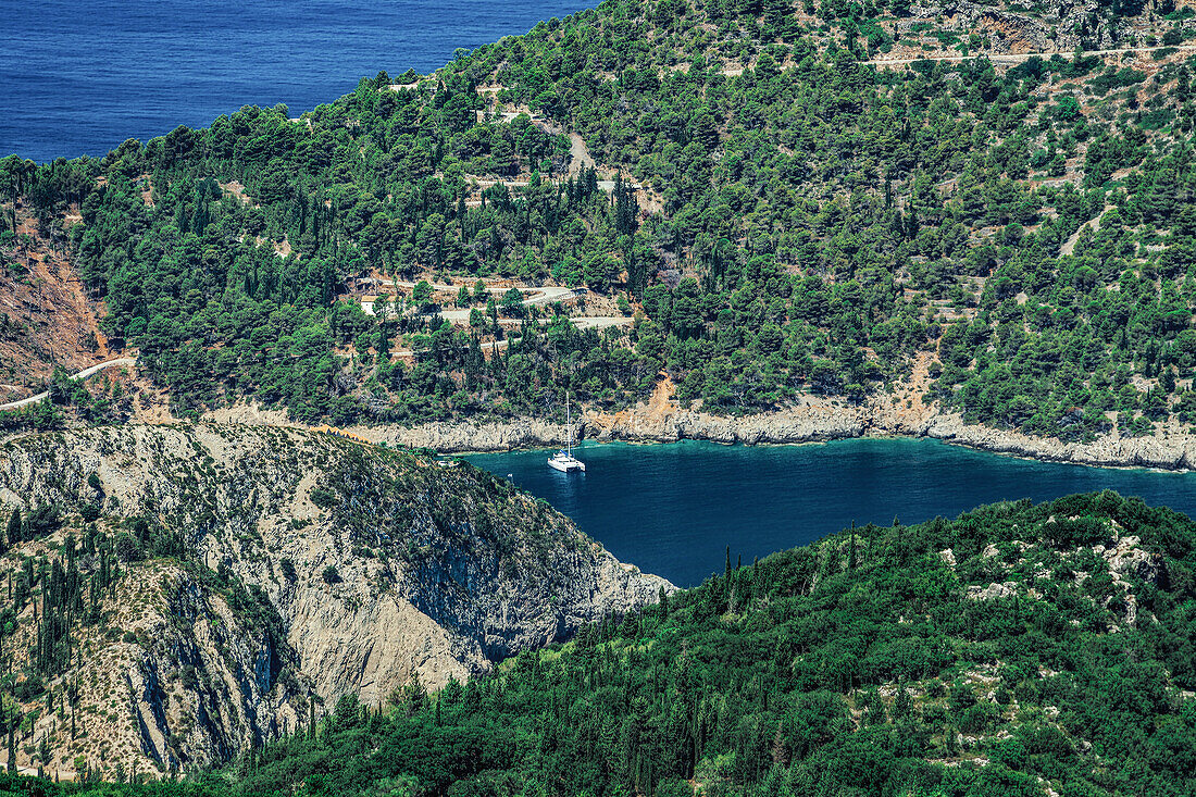 Ländliche Landschaft mit vertäuter Yacht in einem sicheren Hafen, umgeben von grüner Vegetation, Kefalonia, Ionische Inseln, Griechische Inseln, Griechenland, Europa