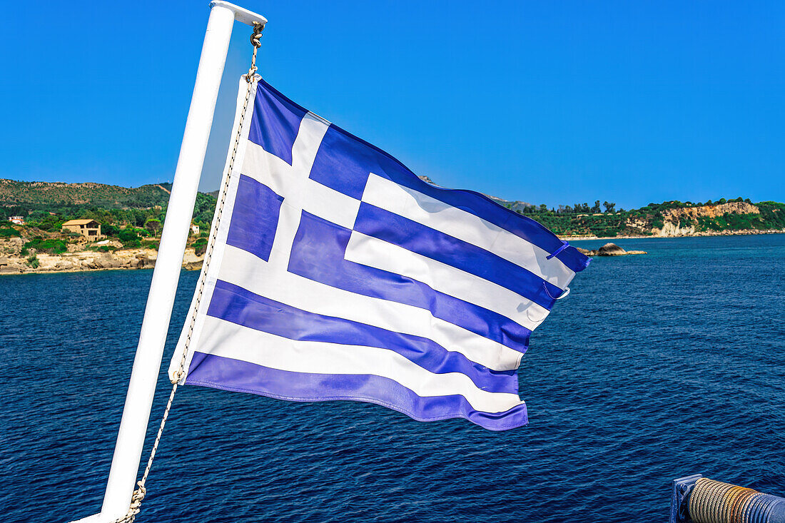 Blue and white Greek flag with cross waving against blue sky, Zakynthos, Ionian Islands, Greek Islands, Greece, Europe