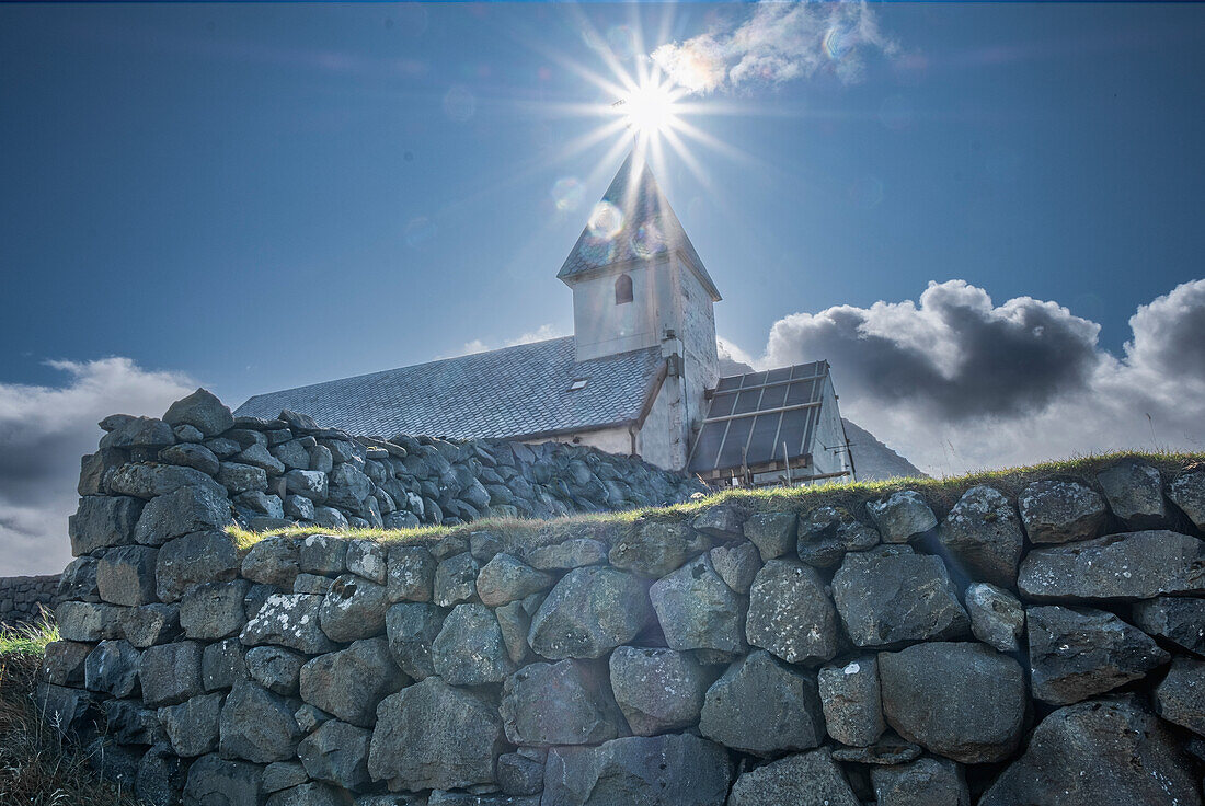 Vioareioi Church and the sun aligned with bell tower, Faroe Islands, Denmark, North Atlantic, Europe