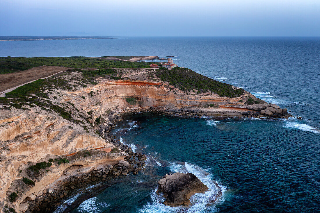 Lighthouse on Mannu Cape wild coast of Sardinia, aerial drone view at sunset, Sardinia, Italy, Mediterranean, Europe