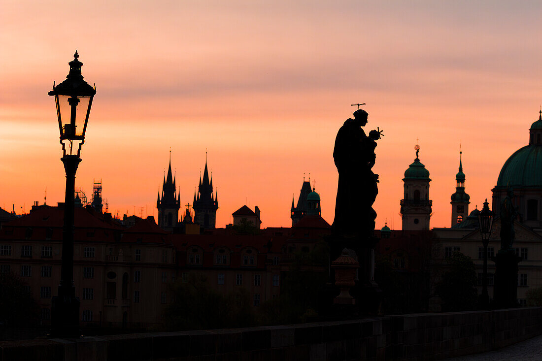 Silhouetten einer Statue an der Karlsbrücke und Türme bei Sonnenaufgang, UNESCO-Welterbe, Prag, Tschechische Republik (Tschechien), Europa