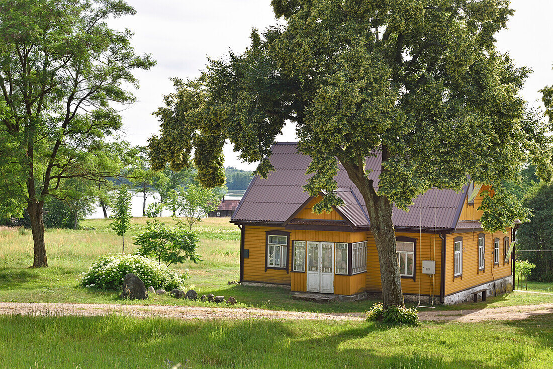 Typical wooden house on the edge of Ukojas lake, near Ginuciai, Aukstaitija National Park, Lithuania, Europe