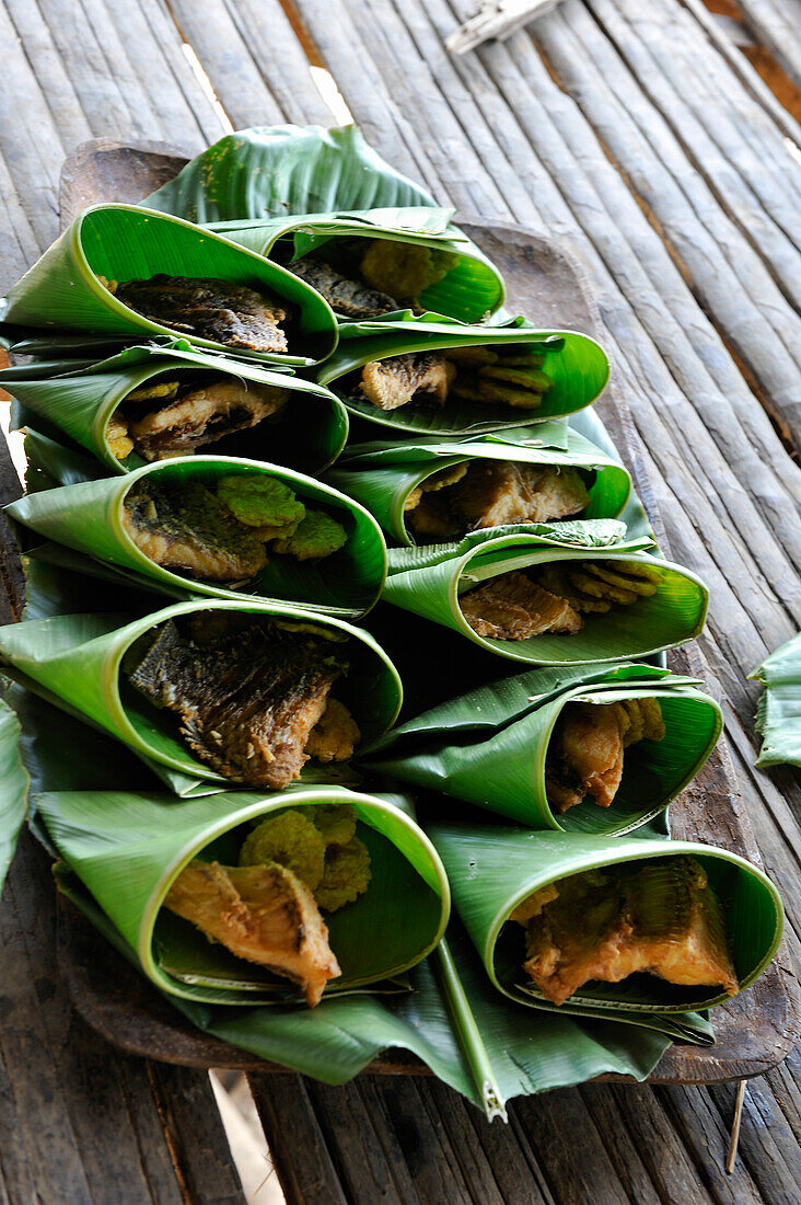 Dishes of fish wrapped in leaves, Embera native community living by the Chagres River within the Chagres National Park, Republic of Panama, Central America