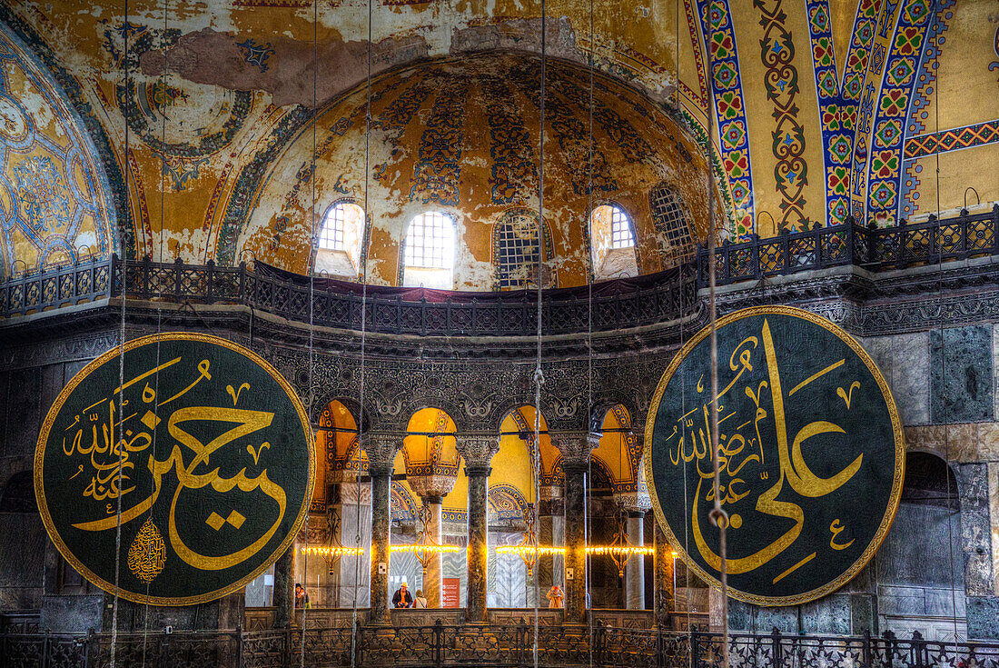 Caligraphy Roundels Naming Hasan, grandson of Mohammed on left and Caliph Alion on right, with tourists viewing from the Gallery, Interior, Hagia Sophia Grand Mosque, 537 AD, UNESCO World Heritage Site, Sultanahmet, Istanbul, Turkey, Europe