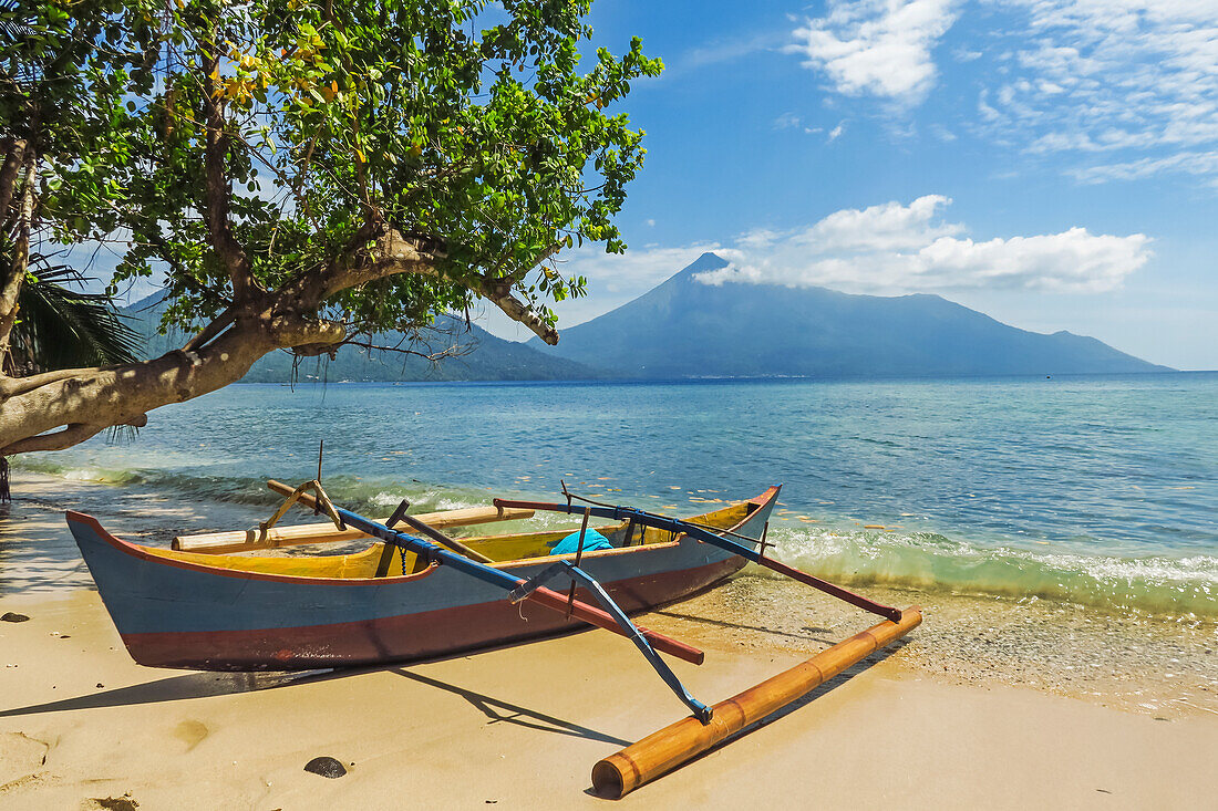 Auslegerkanu am Strand von Kalea mit dem aktiven Vulkan Karangetang dahinter, Kalea, Siau-Insel, Sangihe-Archipel, Nordsulawesi, Indonesien, Südostasien, Asien