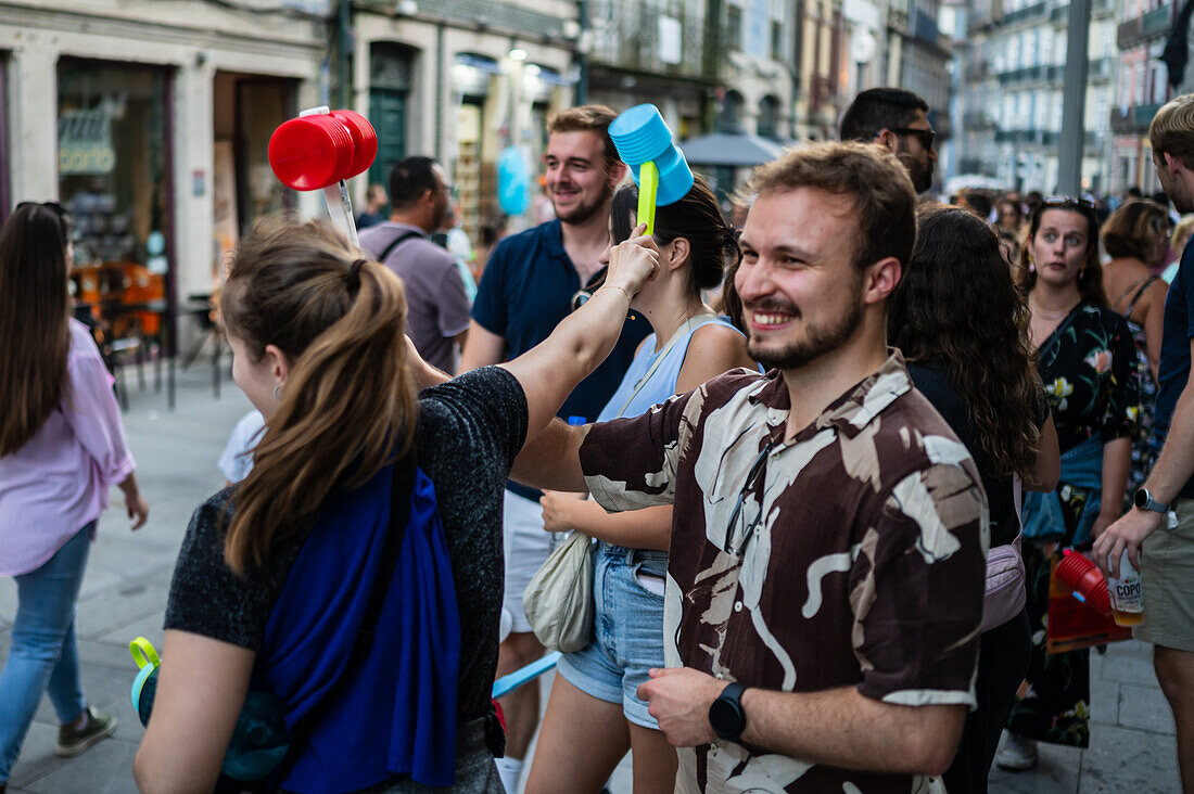 Greeting people with wilting leek and plastic hammers during Festival of St John of Porto (Festa de São João do Porto ) during Midsummer, on the night of 23 June (Saint John's Eve), in the city of Porto, Portugal