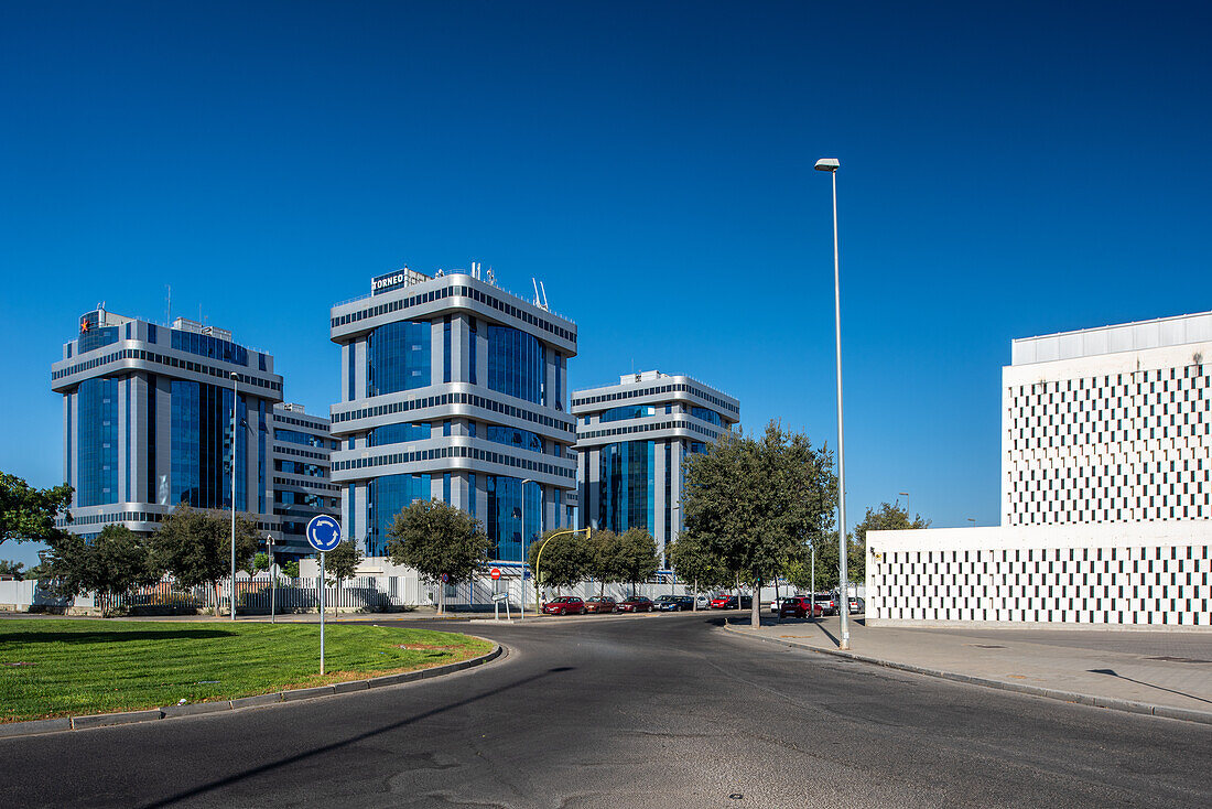 Moderne Bürogebäude im Torneo Business Park in Sevilla, Andalusien, Spanien. Der strahlend blaue Himmel unterstreicht die architektonische Gestaltung.