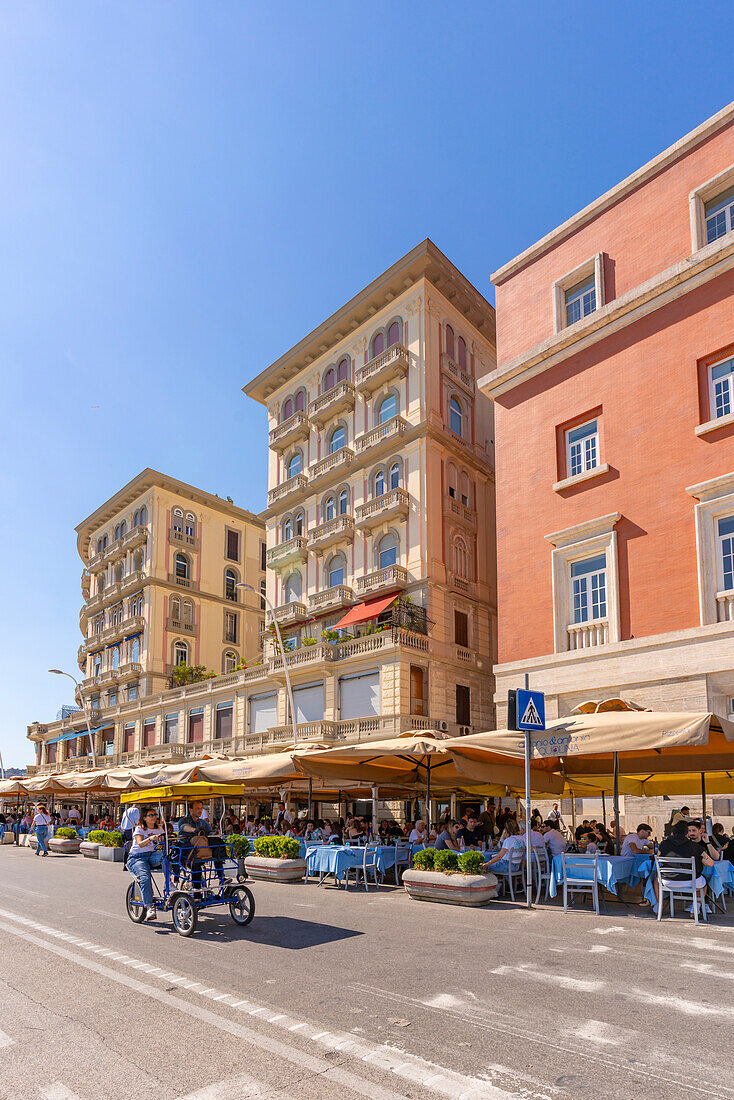 Blick auf pastellfarbene Architektur, Restaurants und Cafés an der Strandpromenade der Via Partenope, Neapel, Kampanien, Italien, Europa