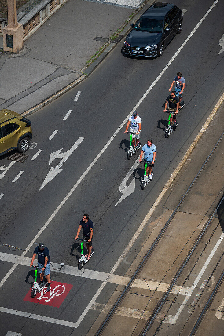 Group of tourists riding scooters, view from above, Prague