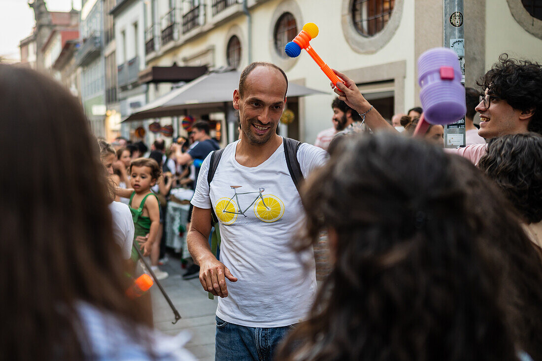 Greeting people with wilting leek and plastic hammers during Festival of St John of Porto (Festa de São João do Porto ) during Midsummer, on the night of 23 June (Saint John's Eve), in the city of Porto, Portugal