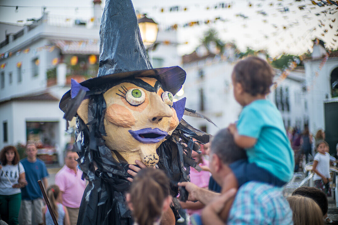 Farbenfrohe Szene vom Festival Gigantes y Cabezudos in Fuenteheridos, Huelva, Andalusien, Spanien. Feierlichkeiten mit großen Puppenfiguren und einer fröhlichen Menschenmenge.