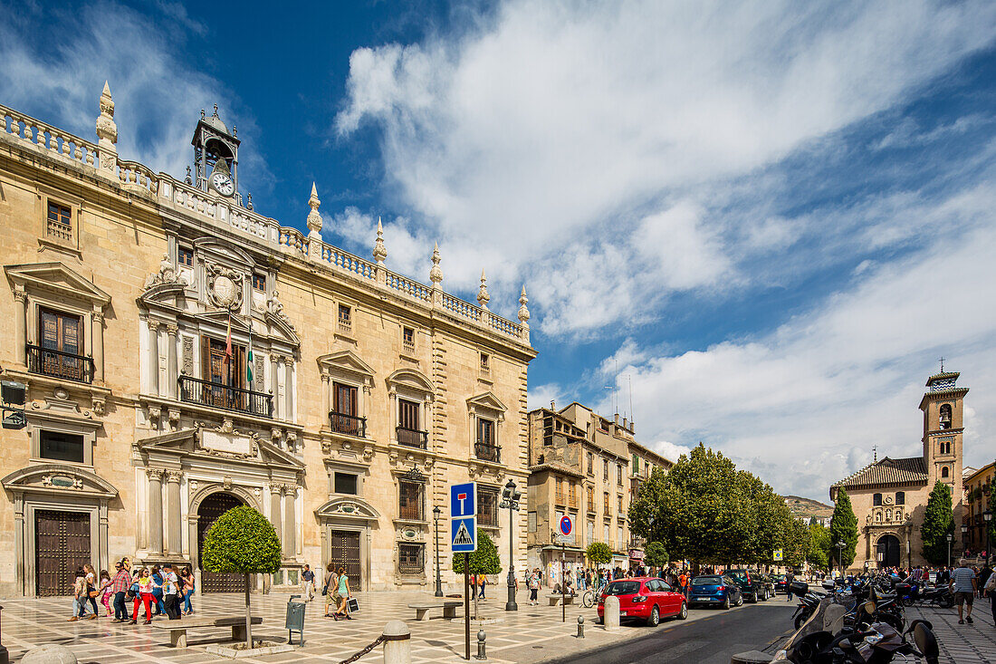 Beautiful view of Edificio de la Audiencia located in Plaza Nueva, Granada, España under a clear blue sky with visitors.