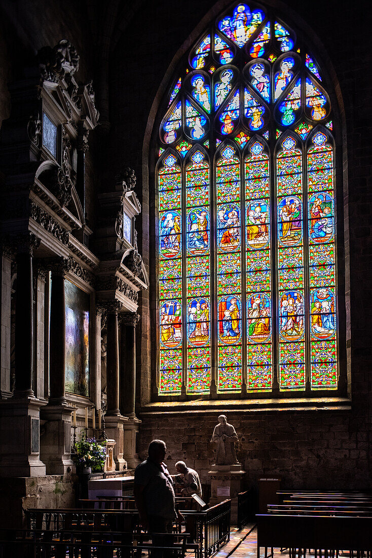 Beautiful stained glass window inside Collegiale Saint Aubin church in Guerande, France. Sunlight streaming through the vibrant colors.