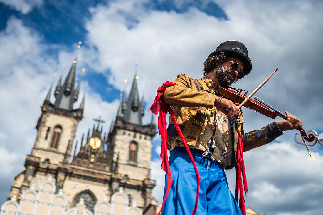 Artist plays violin while walking on stilts at the Parade of puppets from Marián Square to Old Town Square during the Prague Street Theatre Festival Behind the Door, Prague, Czech Republic