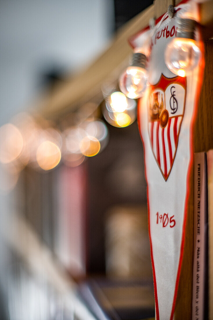 A blurred image of a Sevilla FC banner illuminated by festive string lights. Ideal for celebration and sports-themed visuals.