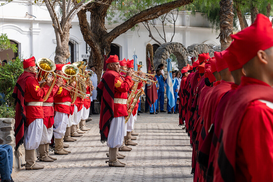 Die Band der Infernales de Guemes, 5. Gebirgsjägerregiment, spielt auf einem Festival in Cachi, Argentinien. Die Uniformen sind denen der ursprünglichen Gaucho-Miliz von General Guemes aus dem Jahr 1815 nachempfunden.