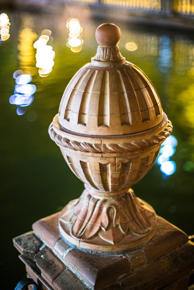 Nahaufnahme eines historischen architektonischen Details an der Plaza de Espana in Sevilla, Spanien, aufgenommen bei Nacht mit schönen Bokeh-Lichtern.