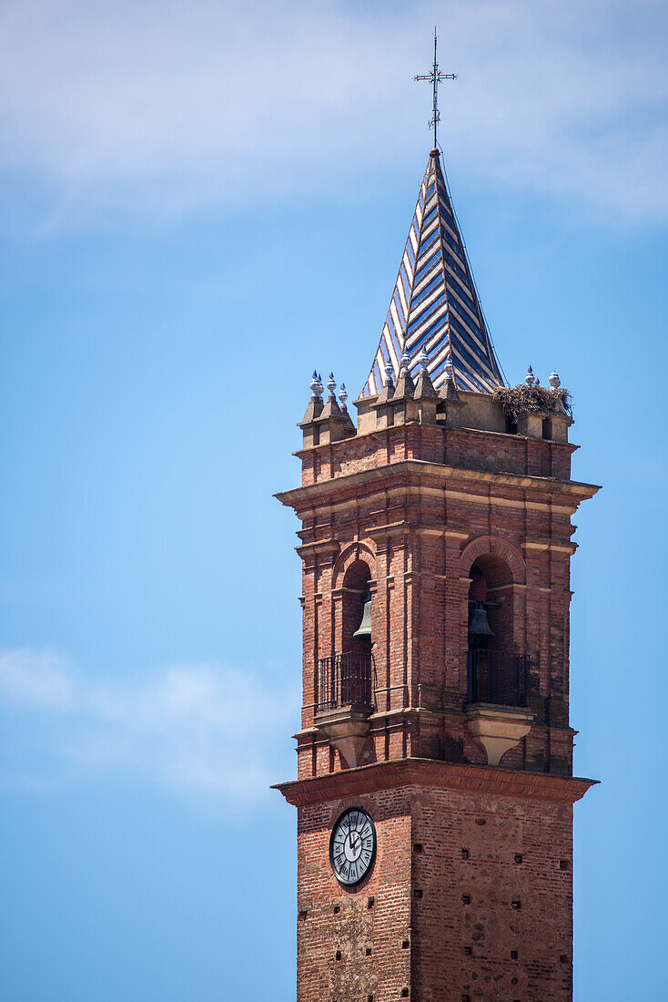 Der Torre de la Iglesia del Espiritu Santo in Fuenteheridos, Provinz Huelva, Andalusien, Spanien, vor einem klaren blauen Himmel.