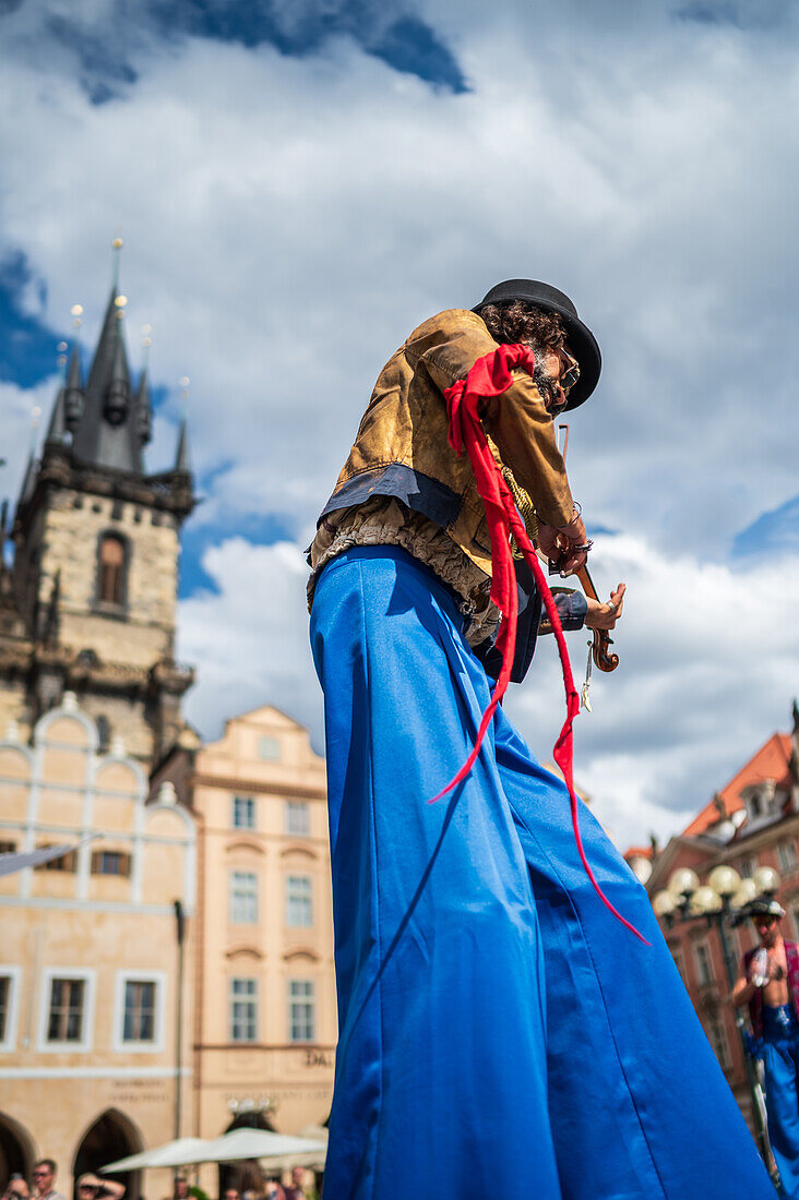 Künstlerin spielt Geige, während sie auf Stelzen bei der Puppenparade vom Marienplatz zum Altstädter Ring läuft, während des Prager Straßentheaterfestivals Behind the Door, Prag, Tschechische Republik