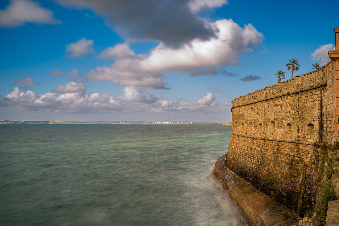 Blick auf die historische Baluarte De La Candelaria mit El Puerto de Santa Maria im Hintergrund, aufgenommen mit einer Langzeitbelichtung.