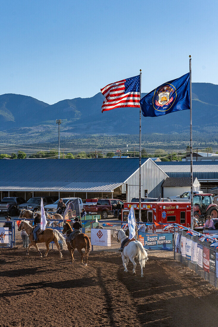 Young cowboys & cowgirls ride past the U.S. and Utah state flags during the Grand Entry at a rodeo in a small rural Utah town.