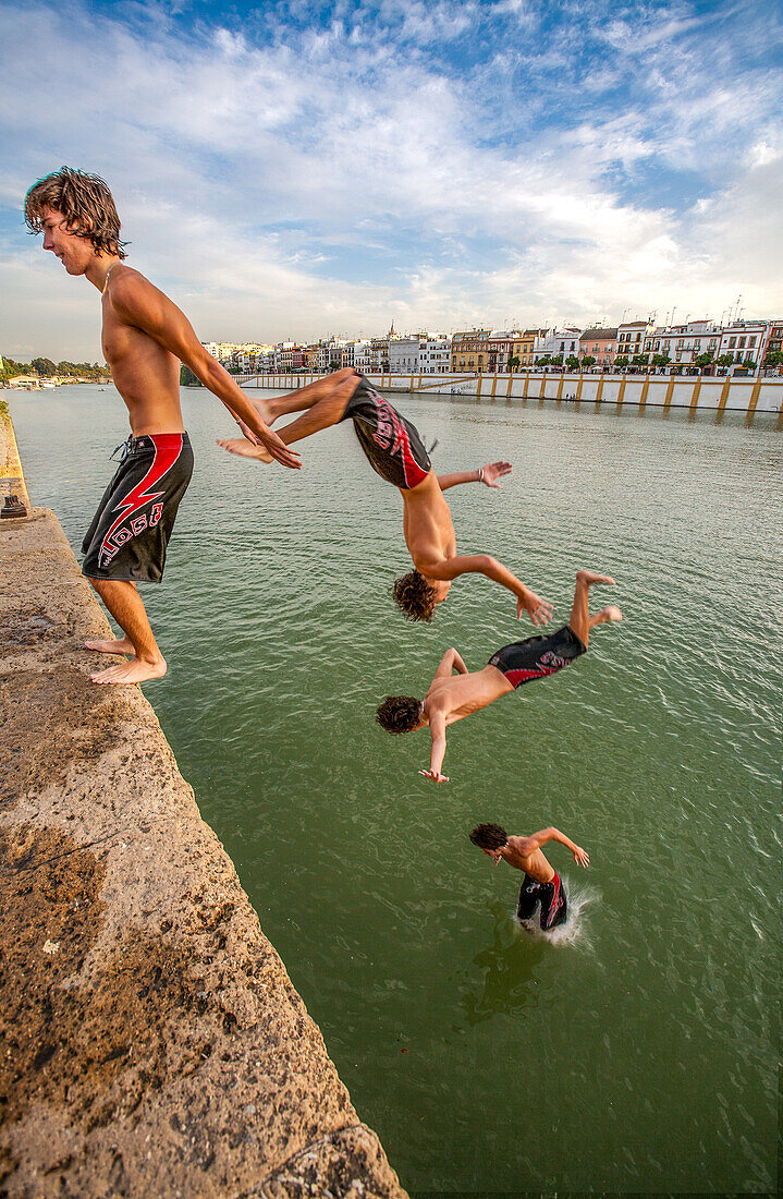 Actionsequenz eines Teenagers, der von einem Felsvorsprung in den Fluss in Sevilla, Spanien, springt und einen schönen Sommertag genießt.